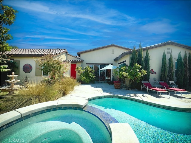 view of pool with a patio and a pool with connected hot tub
