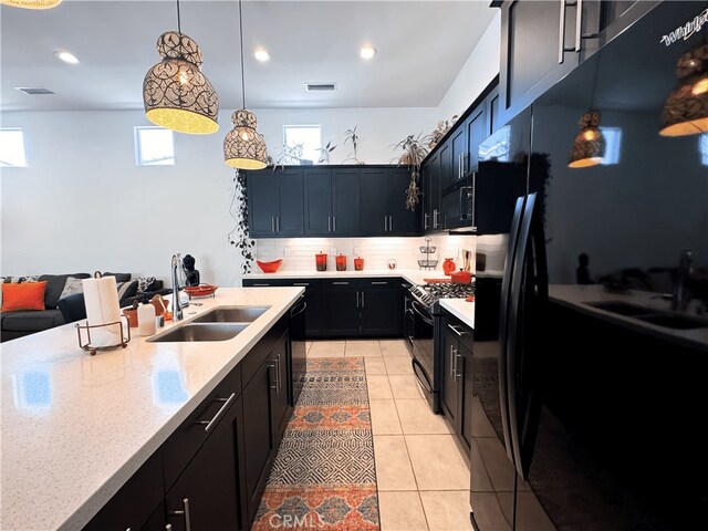 kitchen featuring black appliances, tasteful backsplash, dark cabinets, and a sink