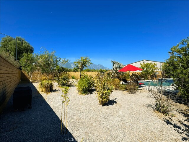 view of yard featuring an outdoor pool and fence