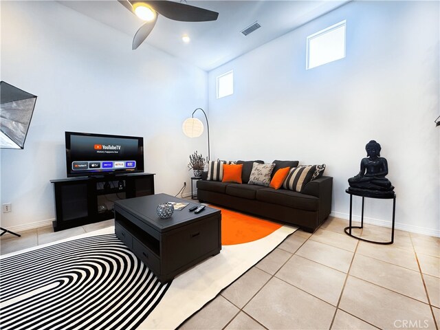 living room featuring light tile patterned floors, a ceiling fan, visible vents, and high vaulted ceiling