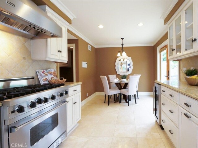 kitchen featuring tasteful backsplash, wall chimney exhaust hood, ornamental molding, stainless steel stove, and beverage cooler