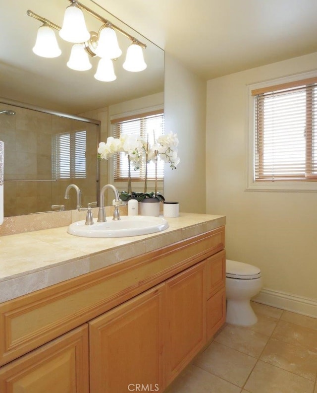 full bath featuring an inviting chandelier, a tile shower, tile patterned flooring, toilet, and vanity