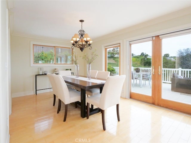 dining room with baseboards, a notable chandelier, light wood-style floors, and crown molding