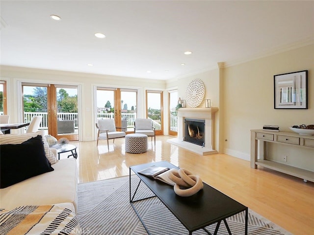 4911 Browndeer Ln, Rancho Palos Verdes, CA 90275 - living room featuring crown molding, light wood-style flooring, a warm lit fireplace, baseboards, and recessed lighting