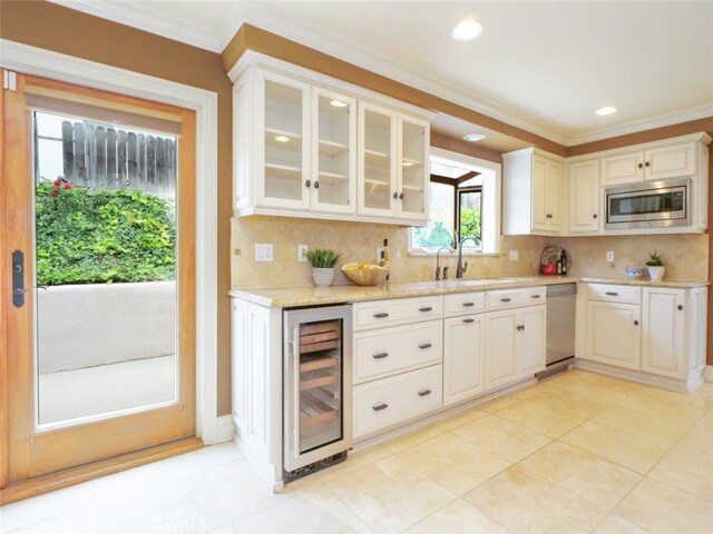 kitchen featuring wine cooler, a sink, appliances with stainless steel finishes, and decorative backsplash