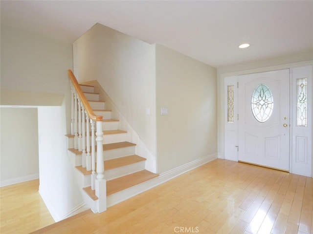 foyer entrance with recessed lighting, stairway, wood finished floors, and baseboards