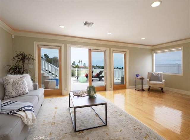 living room with visible vents, ornamental molding, wood finished floors, and recessed lighting