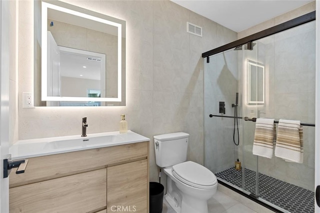 full bathroom featuring visible vents, a stall shower, vanity, tile patterned floors, and toilet
