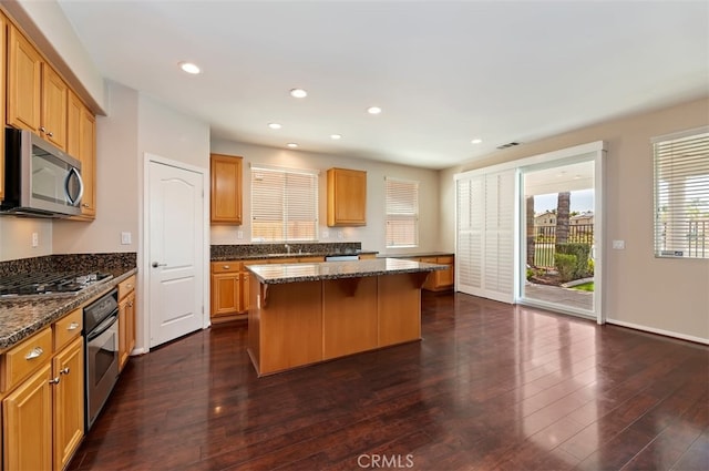 29855 Bay View Way, Menifee, CA 92584 - kitchen featuring dark wood finished floors, dark stone countertops, stainless steel appliances, a center island, and visible vents