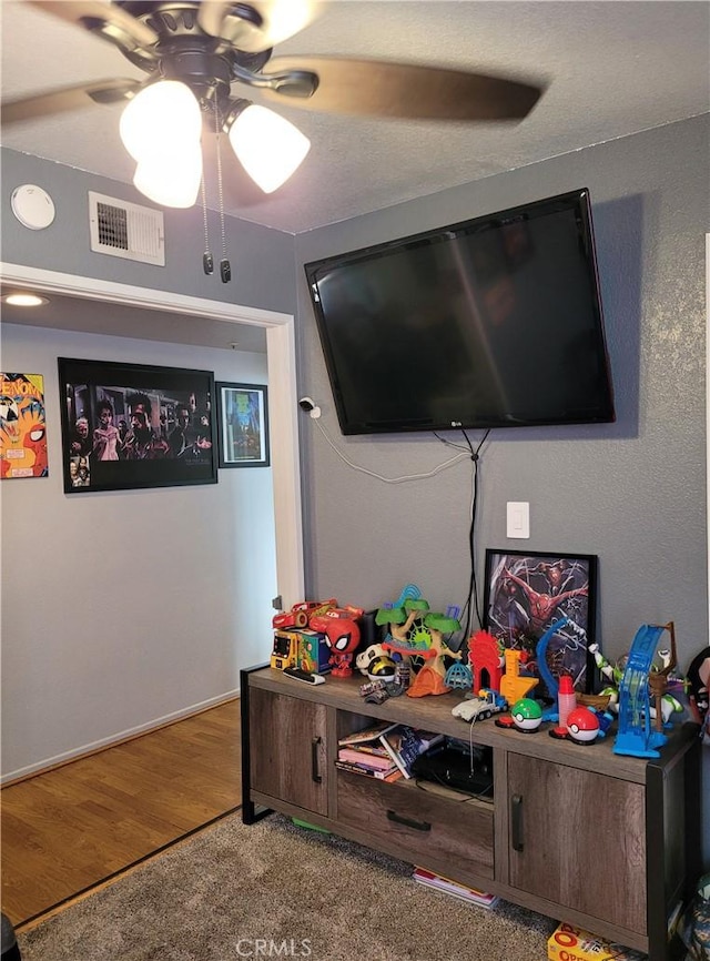 rec room featuring a ceiling fan, visible vents, and wood finished floors