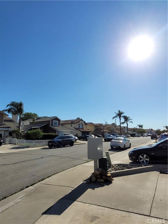 view of street with a residential view, sidewalks, and curbs