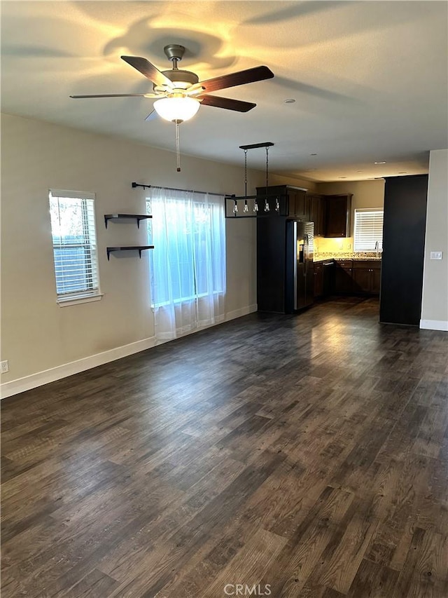 16 Petaluma Ct, Chico, CA 95926 - unfurnished living room featuring a ceiling fan, dark wood-type flooring, healthy amount of natural light, and baseboards