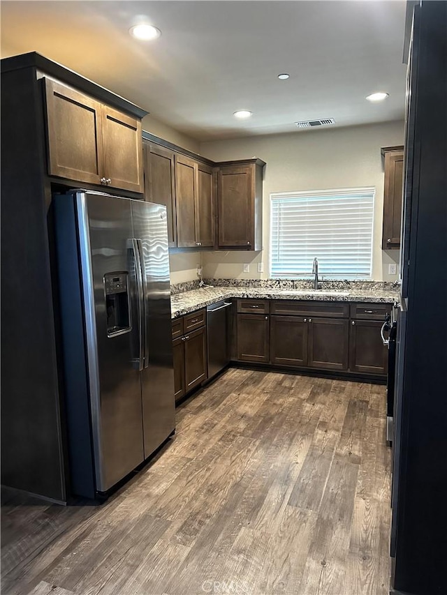 16 Petaluma Ct, Chico, CA 95926 - kitchen with stainless steel appliances, a sink, wood finished floors, dark brown cabinets, and light stone counters