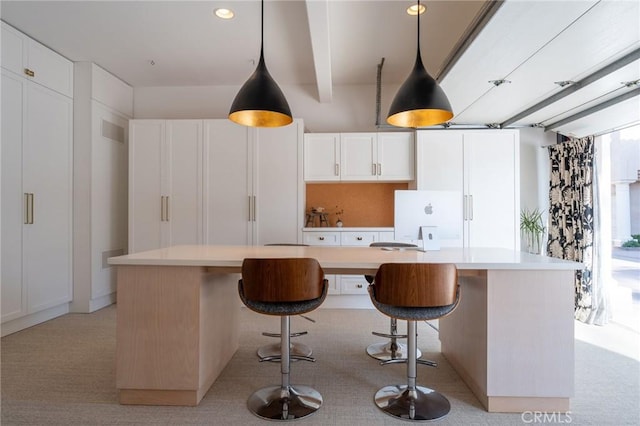 kitchen featuring a center island, white cabinets, and light carpet
