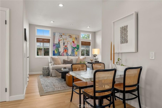 dining room featuring baseboards, recessed lighting, a healthy amount of sunlight, and light wood-style flooring