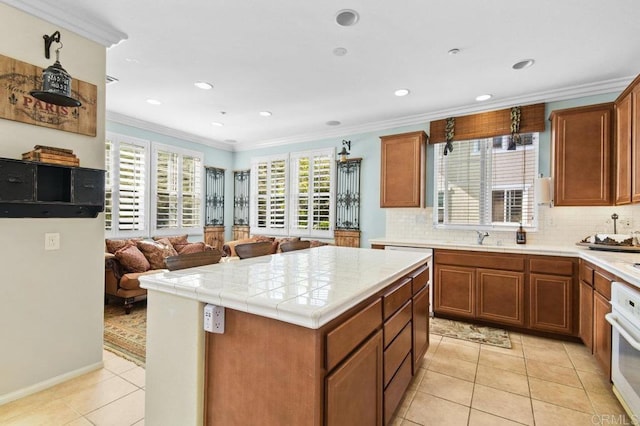 kitchen featuring light tile patterned flooring, tasteful backsplash, oven, ornamental molding, and open floor plan
