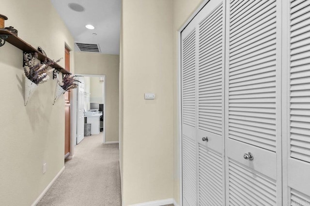 hallway featuring visible vents, carpet, and baseboards