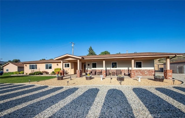view of front of house featuring a patio and brick siding