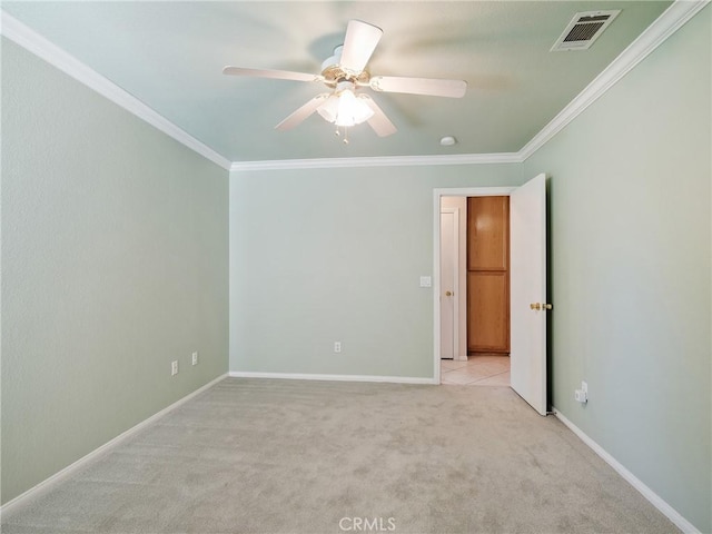 empty room with visible vents, crown molding, baseboards, ceiling fan, and light colored carpet