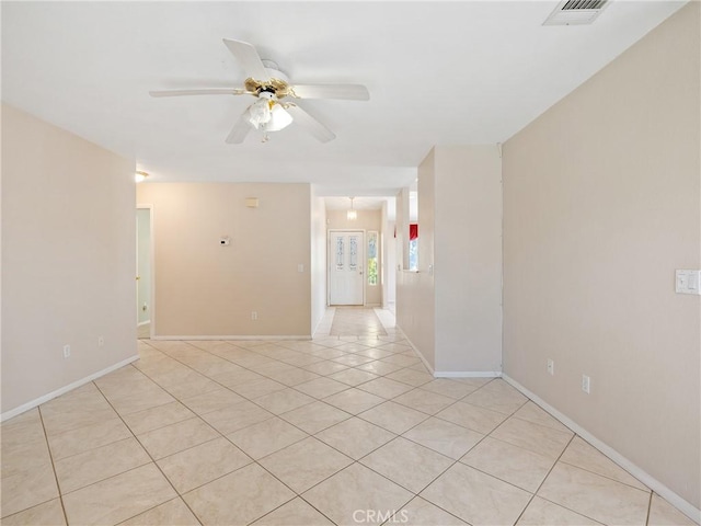 empty room featuring light tile patterned floors, baseboards, a ceiling fan, and visible vents