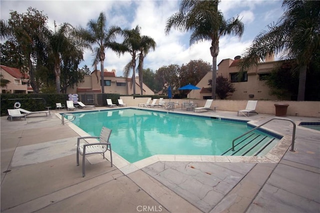 community pool featuring a patio and fence