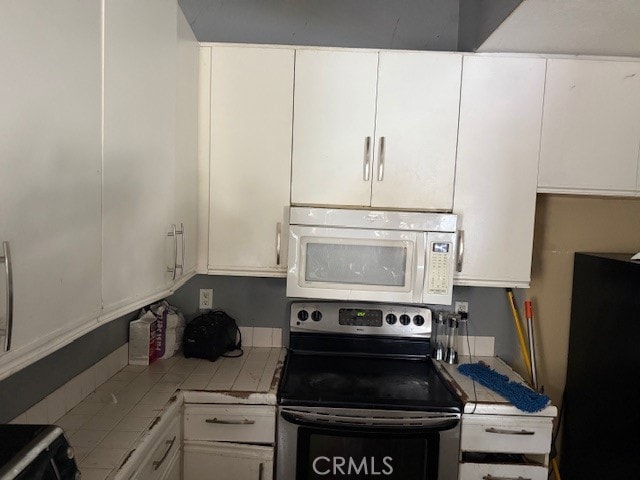 82 Largo St, Laguna Niguel, CA 92677 - kitchen featuring stainless steel electric range oven, white microwave, tile countertops, and white cabinets