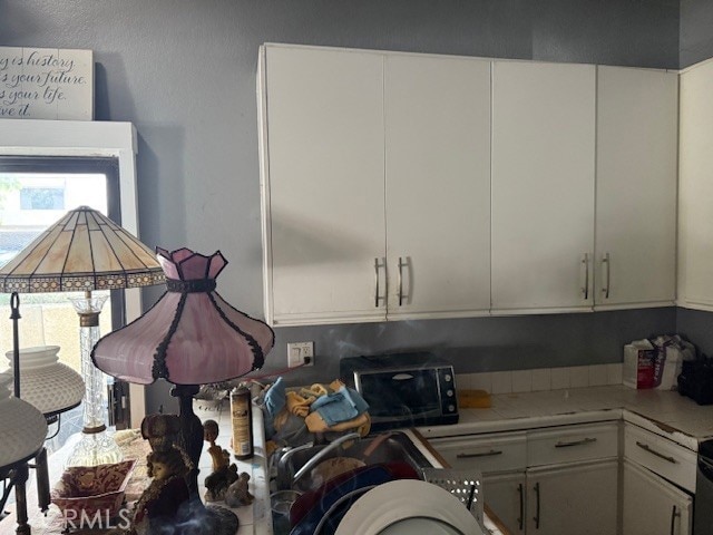 82 Largo St, Laguna Niguel, CA 92677 - kitchen with black microwave, light countertops, and white cabinets