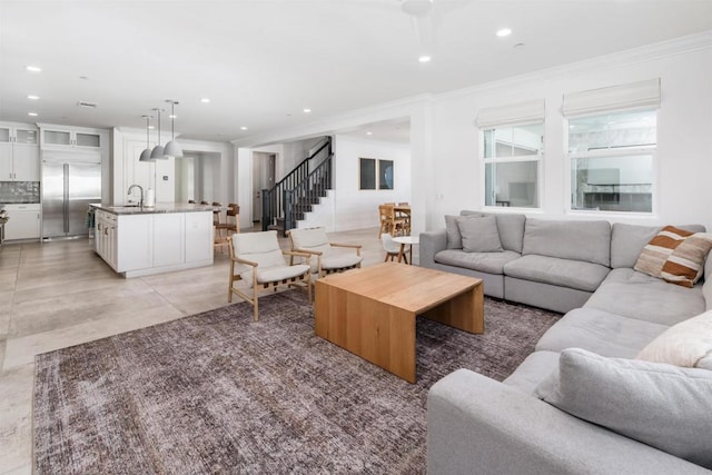 living room featuring light tile patterned floors, crown molding, recessed lighting, and stairs
