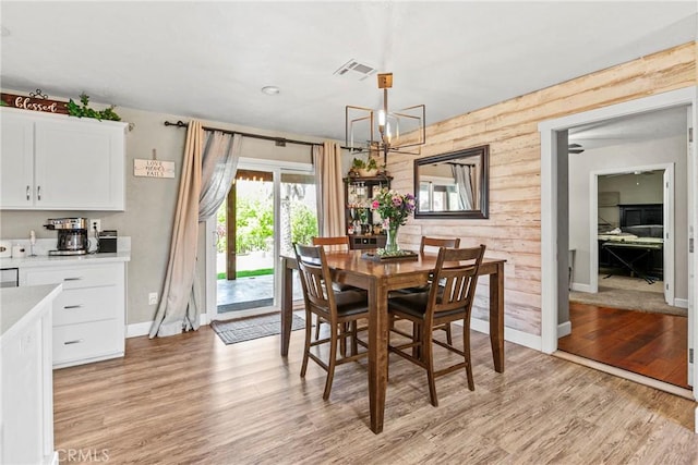 7440 Shale Rock Rd, Paso Robles, CA 93446 - dining room with a chandelier, light wood finished floors, baseboards, and wood walls