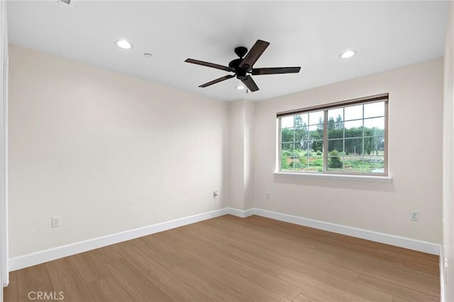 spare room featuring recessed lighting, a ceiling fan, wood finished floors, and baseboards