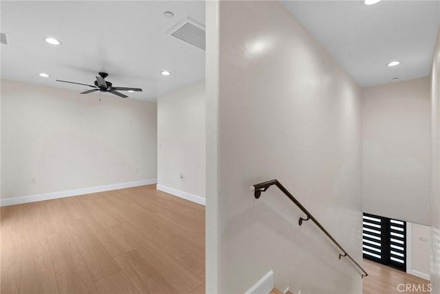 stairway featuring baseboards, recessed lighting, wood finished floors, and a ceiling fan