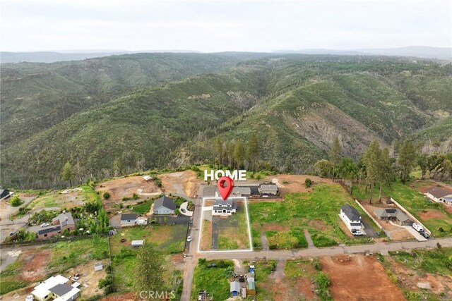 drone / aerial view with a mountain view and a view of trees