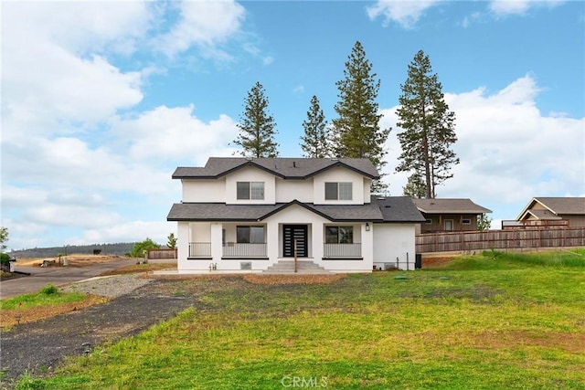 view of front of house featuring a front yard, stucco siding, and fence