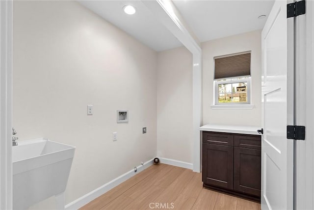laundry room with hookup for a washing machine, laundry area, electric dryer hookup, light wood-style floors, and baseboards