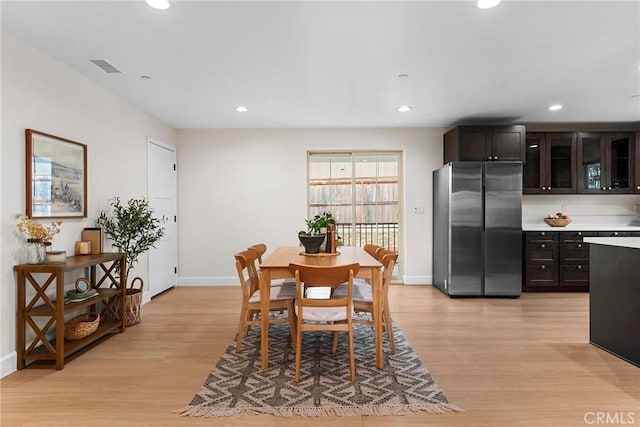 dining area featuring baseboards, visible vents, light wood finished floors, and recessed lighting