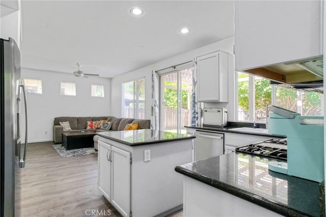 kitchen with recessed lighting, stainless steel appliances, ceiling fan, a kitchen island, and white cabinets