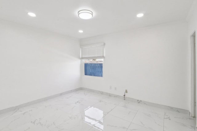 unfurnished room with recessed lighting, marble finish floor, and baseboards