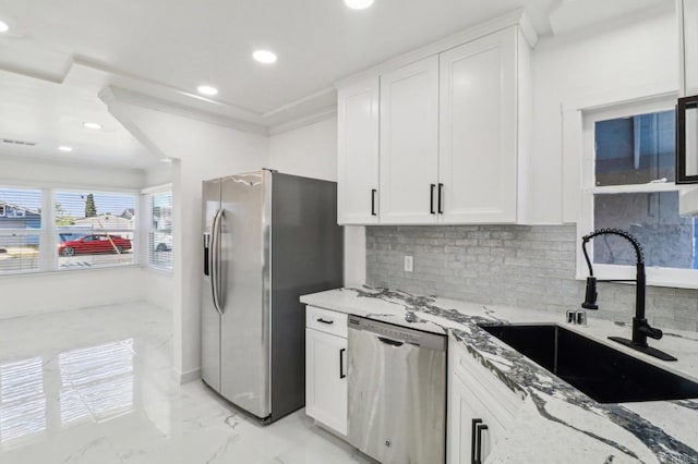 kitchen with light stone counters, a sink, stainless steel appliances, recessed lighting, and marble finish floor