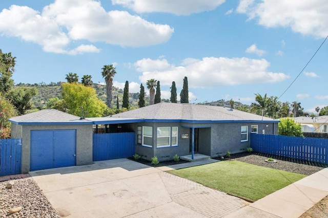 view of front of house featuring stucco siding, fence, an outbuilding, driveway, and a front yard