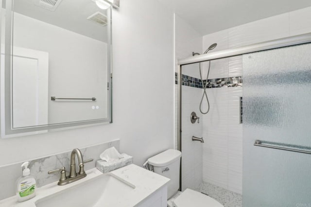 full bath with vanity, toilet, visible vents, and a stall shower