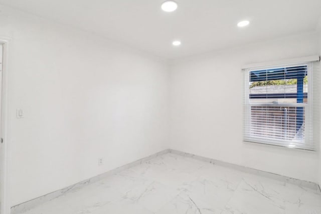 unfurnished room with recessed lighting, marble finish floor, and baseboards