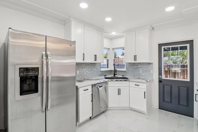 kitchen with stainless steel appliances, plenty of natural light, ornamental molding, and a sink