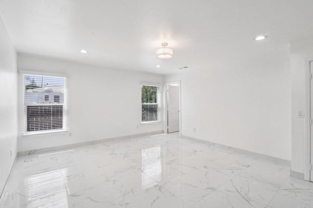 unfurnished room featuring baseboards, recessed lighting, and marble finish floor