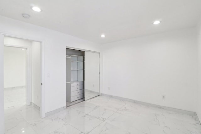 unfurnished bedroom featuring recessed lighting, marble finish floor, and baseboards