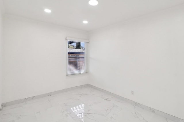 empty room featuring recessed lighting, marble finish floor, and baseboards