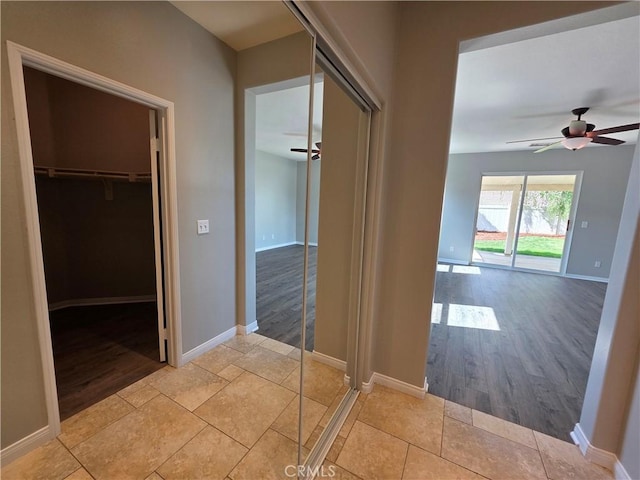 hall featuring light wood-style flooring and baseboards
