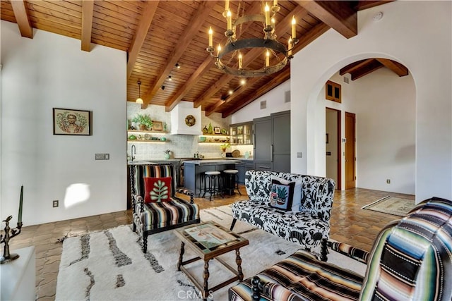 2020 N Victoria Dr, Santa Ana, CA 92706 - living area featuring arched walkways, a chandelier, wood ceiling, beam ceiling, and stone tile flooring