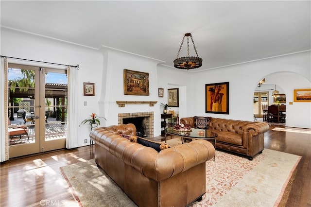 2020 N Victoria Dr, Santa Ana, CA 92706 - living room with arched walkways, wood finished floors, french doors, and a brick fireplace