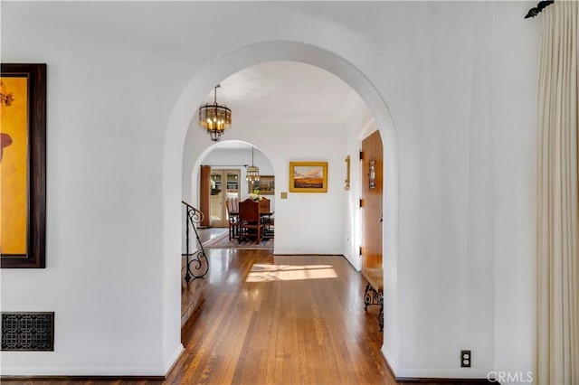 2020 N Victoria Dr, Santa Ana, CA 92706 - corridor with arched walkways, wood finished floors, a chandelier, and baseboards