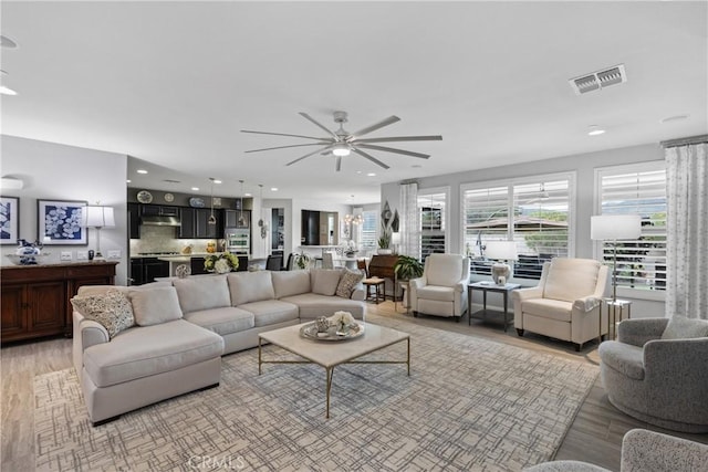 living area with ceiling fan, visible vents, light wood-type flooring, and recessed lighting